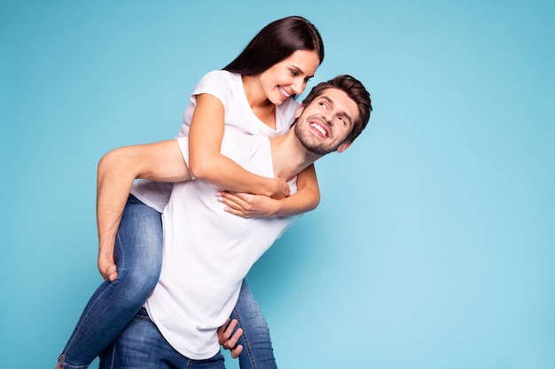 Portrait de jeune couple posant sur un mur de couleur bleue