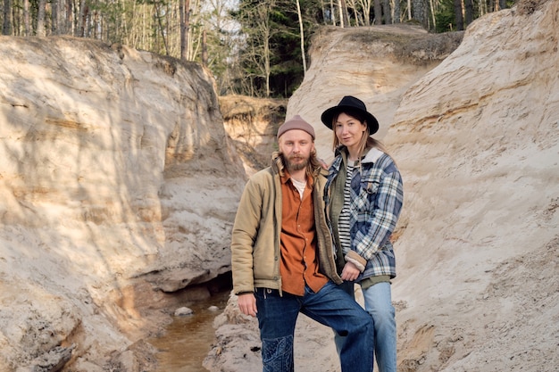 Portrait de jeune couple de randonneurs regardant la caméra tout en voyageant ensemble à l'extérieur parmi les rochers