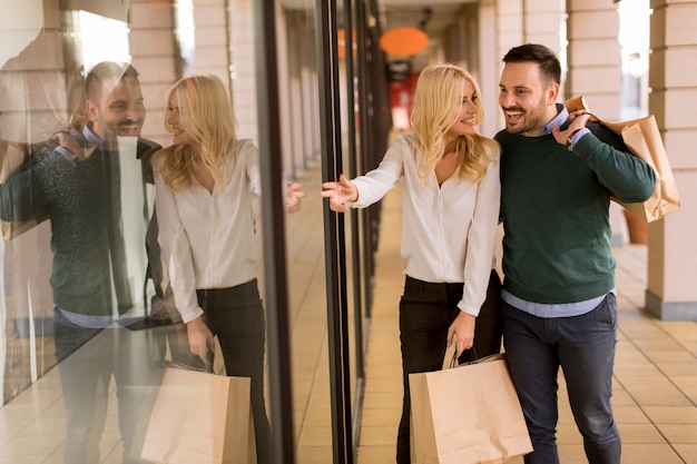 Portrait de jeune couple avec des sacs à provisions en ville