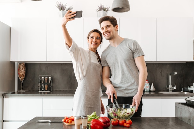 Portrait d'un jeune couple souriant prenant un selfie