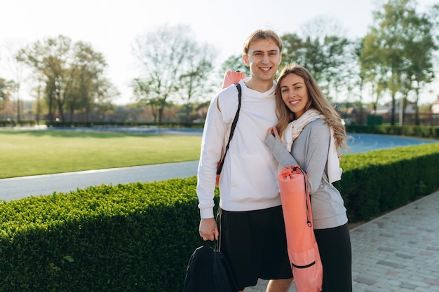 Portrait de jeune couple sportif en vêtements de sport est venu s'entraîner à l'extérieur avec des équipements sportifs mode de vie sain