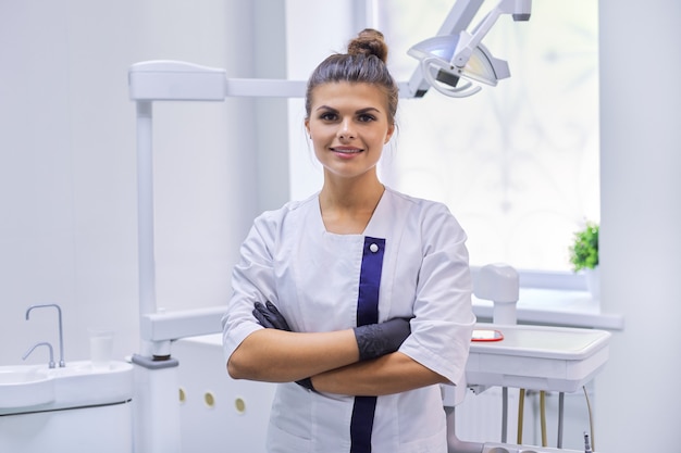 Portrait de jeune dentiste souriant confiant au bureau de dentisterie