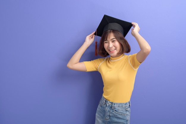 Un Portrait De Jeune étudiant Asiatique Portant Une Casquette De Graduation Sur Fond De Studio.