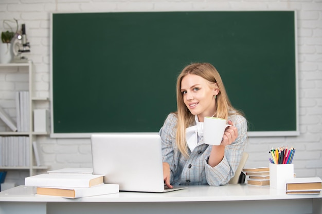 Portrait d'un jeune étudiant souriant buvant du café ou du thé étudiant en classe