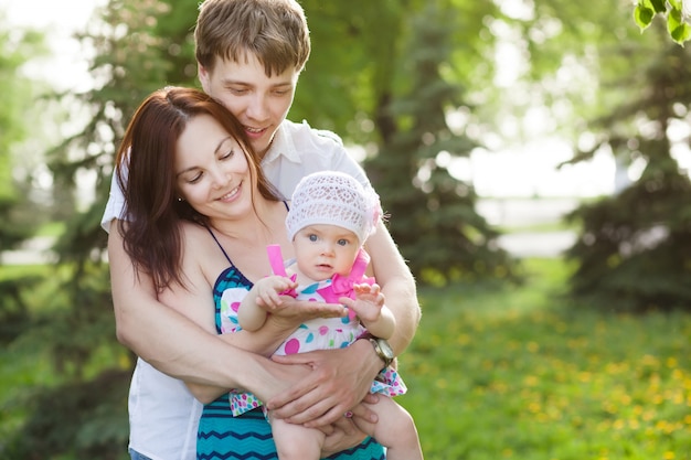 Portrait de jeune famille avec petite fille dans le parc d'été