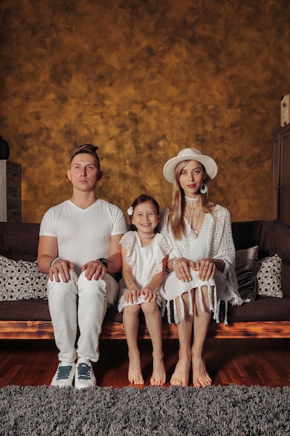 Portrait jeune famille en vêtements blancs à la maison à l'intérieur du salon