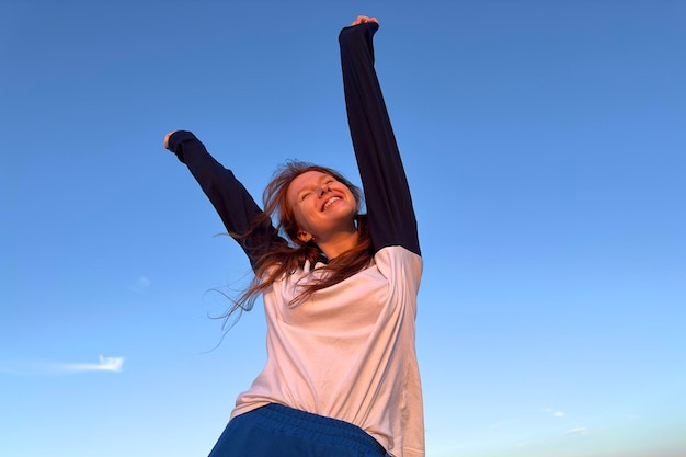 Portrait de jeune femme adolescente s'amusant à l'extérieur à la campagne en regardant la caméra et le sourire