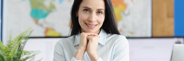 Portrait de jeune femme d'affaires assise au lieu de travail de table