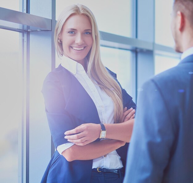 Portrait de jeune femme d'affaires au bureau avec des collègues en arrière-plan