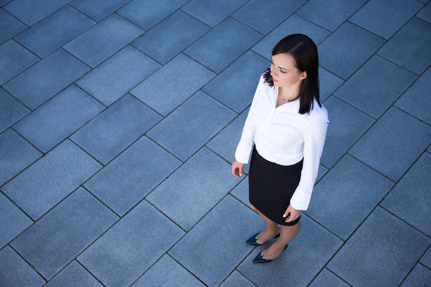 Portrait de jeune femme d'affaires belle sur fond de carrelage