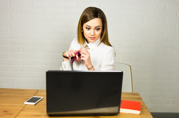 Portrait jeune femme d'affaires choqué assis devant un ordinateur portable en regardant l'écran.