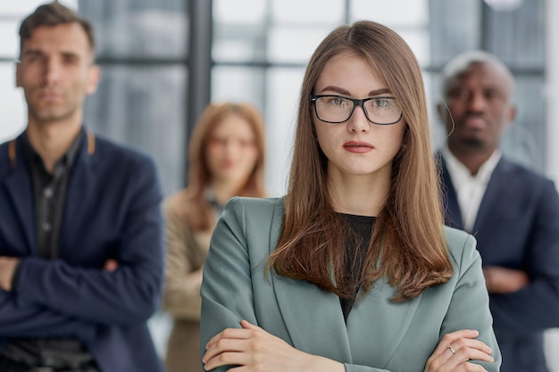 Portrait d'une jeune femme d'affaires confiante debout les bras croisés dans un bureau