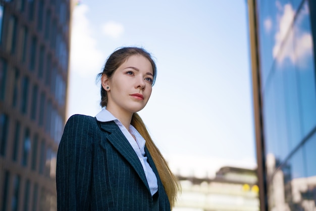 Portrait d'une jeune femme d'affaires dans la rue près du centre de bureaux. Dans une veste noire et une chemise blanche