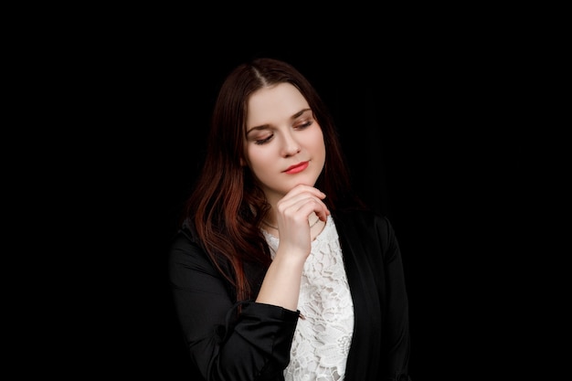 Portrait de jeune femme d'affaires dans une veste noire pense