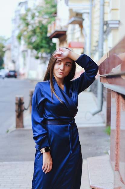 Photo portrait d'une jeune femme d'affaires élégante vêtue d'une longue robe bleue et de longs cheveux noirs