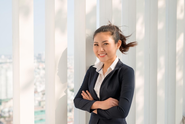 Portrait d'une jeune femme d'affaires heureuse dans un environnement moderne