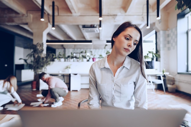 Portrait d'une jeune femme d'affaires intelligente assise à sa table de travail au bureau