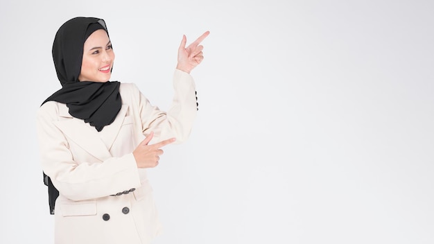 Portrait de jeune femme d'affaires musulmane souriante portant un costume avec hijab sur fond blanc studio.