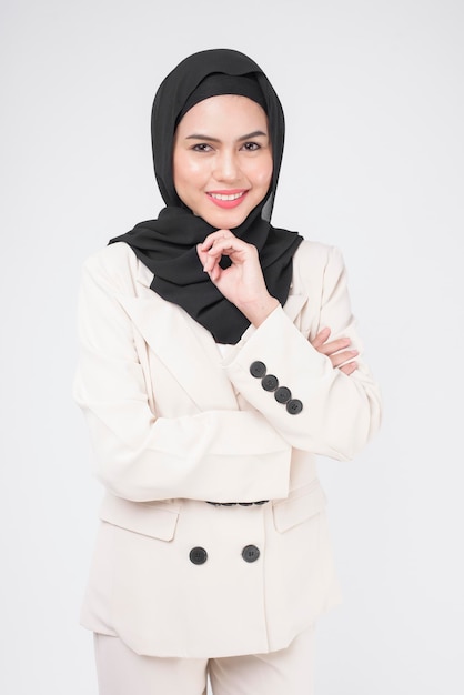 Portrait de jeune femme d'affaires musulmane souriante portant un costume avec hijab sur fond blanc studio.