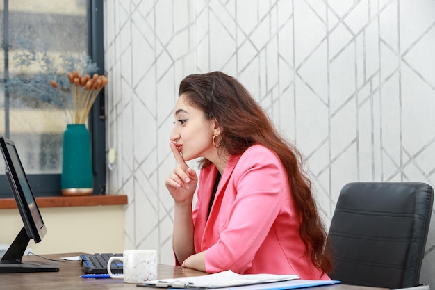 Le portrait d'une jeune femme d'affaires parlant sur l'appel vidéo et le geste silencieux