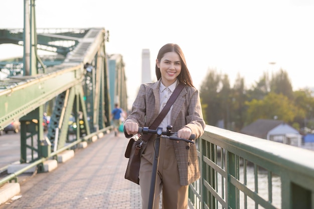 Portrait de jeune femme d'affaires avec un scooter électrique pour travailler o