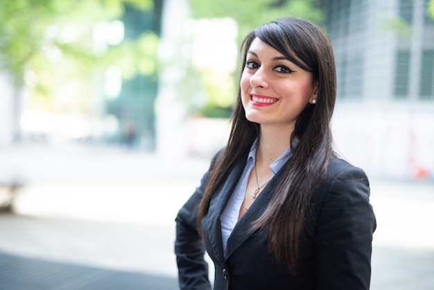 Portrait d'une jeune femme d'affaires souriante en plein air