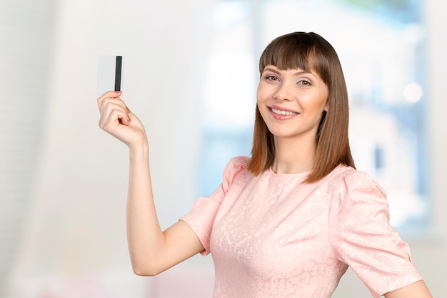 portrait de jeune femme d'affaires souriante tenant une carte de crédit