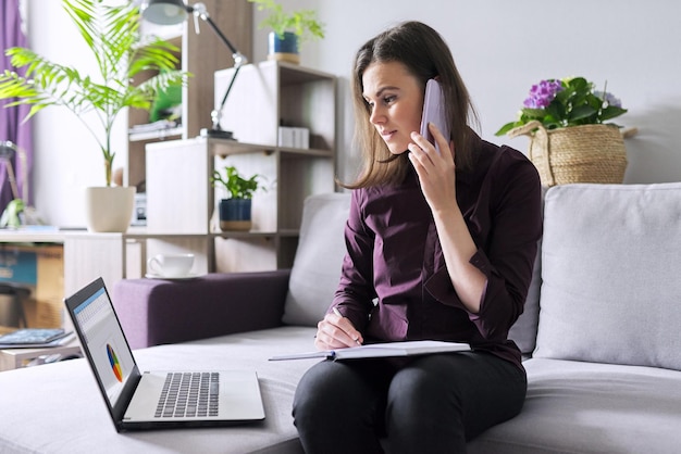 Portrait de jeune femme d'affaires travaillant à la maison