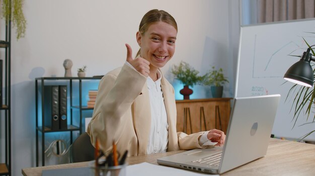 Photo portrait d'une jeune femme d'affaires utilisant un ordinateur portable assise sur une table