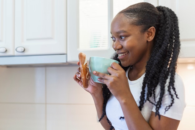 Portrait de jeune femme africaine buvant une tasse de café Pearl From The East. Femme souriante tenant une tasse de café.