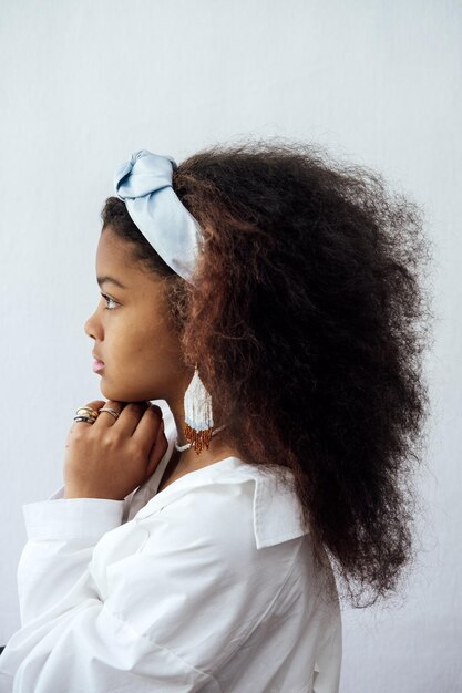 Portrait d'une jeune femme africaine avec un foulard et des bijoux ethniques.