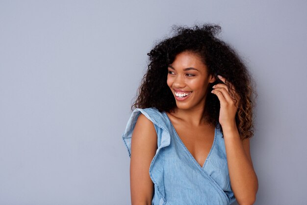 Portrait de jeune femme afro-américaine heureuse souriant sur fond gris