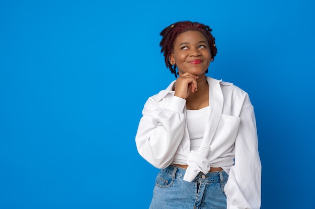 Portrait de jeune femme afro-américaine réfléchie sur fond bleu