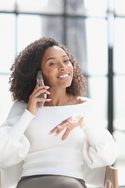 Portrait d'une jeune femme afro-américaine séduisante à l'aide d'un smartphone
