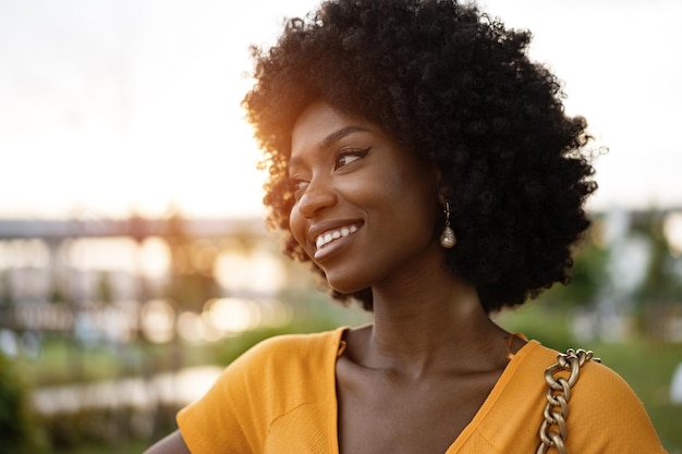 Portrait d'une jeune femme afro-américaine souriante debout à la ville