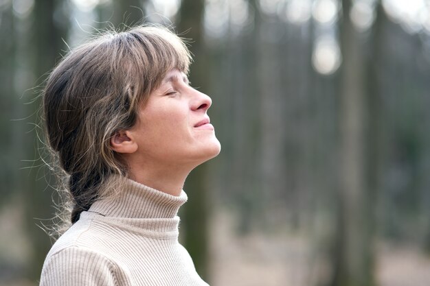 Portrait de jeune femme appréciant une chaude journée à l'extérieur.