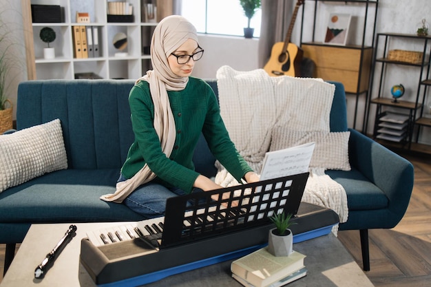 Portrait de jeune femme arabe avec hijab jouant au piano