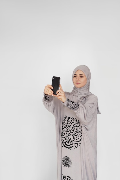 Portrait d'une jeune femme arabe souriante parlant au téléphone mobile