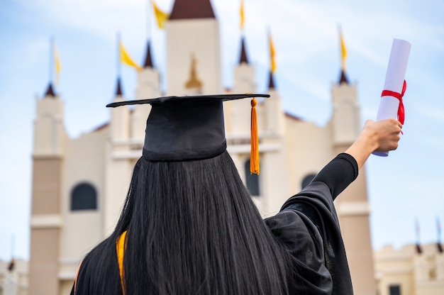 Portrait de jeune femme asiatique avec diplôme à l'extérieur