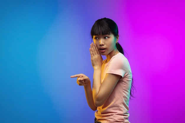 Portrait de jeune femme asiatique sur fond de studio dégradé en néon