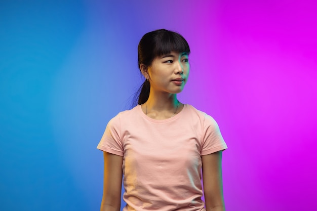 Portrait de jeune femme asiatique sur fond de studio dégradé en néon