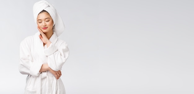 Portrait d'une jeune femme asiatique heureuse en peignoirIsolé sur fond blanc