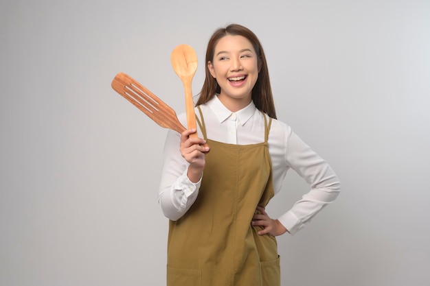 Portrait de jeune femme asiatique portant un tablier sur fond blanc studio