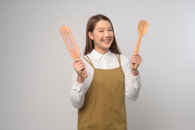 Portrait de jeune femme asiatique portant un tablier sur fond blanc studio