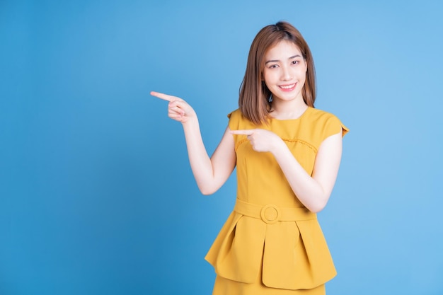 Portrait de jeune femme asiatique posant sur fond bleu