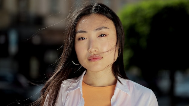 Portrait d'une jeune femme asiatique en tenue décontractée regardant la caméra à l'extérieur sur le visage en gros plan de la rue d'une belle fille asiatique debout dans les rues de la ville été belle dame portrait heureux en plein air