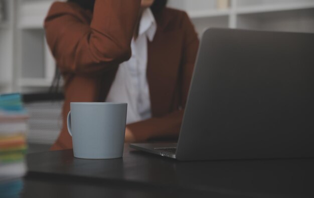 Portrait d'une jeune femme asiatique travaillant à la main sur une tablette informatique dans un bureau moderne. Faire un rapport d'analyse comptable sur les données d'investissement immobilier Concept de systèmes financiers et fiscaux