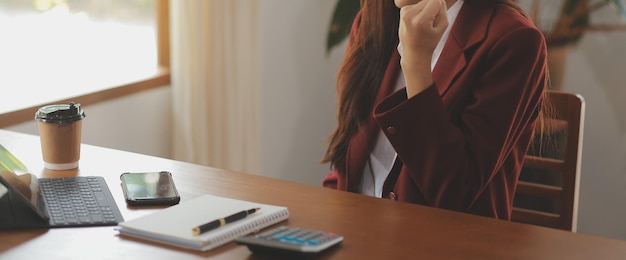 Portrait d'une jeune femme asiatique travaillant à la main sur une tablette informatique dans un bureau moderne. Faire un rapport d'analyse comptable sur les données d'investissement immobilier Concept de systèmes financiers et fiscaux