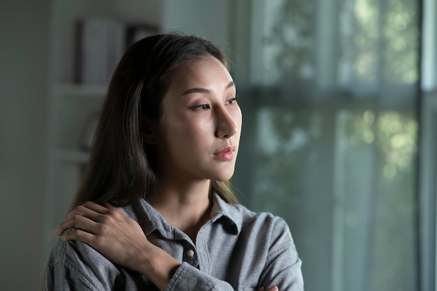 Portrait d'une jeune femme asiatique triste et inquiète dans le salon