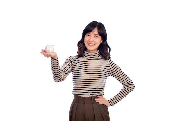 Portrait de jeune femme asiatique uniforme décontracté tenant une tirelire blanche isolée sur fond blanc Concept d'économie d'argent financier et bancaire